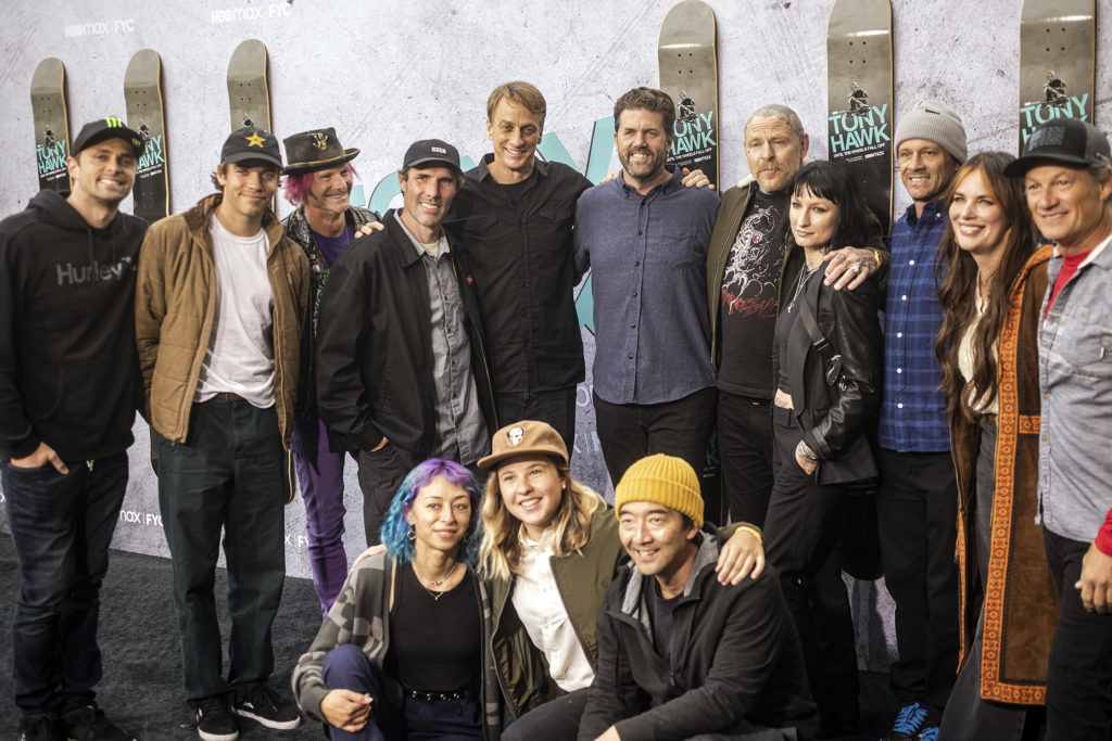 Tony Hawk stands for a group photo with other skateboarders.